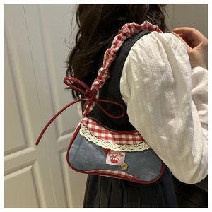 Détail du sac à bandoulière en denim et vichy avec dentelle et broderie cerise