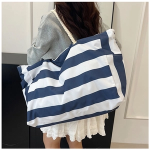 Macro shot of blue and white striped tote bag showing durable rope handle and side pocket