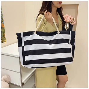 Close-up of oversized striped canvas tote bag with cotton rope handles and metal rings