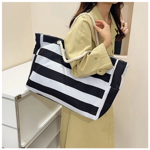 Detail of striped canvas tote bag with thick cotton rope handle and side storage pocket