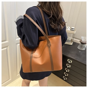 Dettaglio della borsa tote color caramello con trama in pelle fine e spalline sottili
