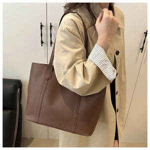 Dettaglio della borsa tote marrone minimalista con trama in pelle e spalline sottili