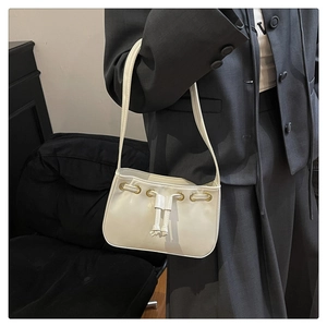 Detail of ivory PU leather bag showing gold grommets and drawstring decorative elements
