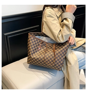 Close-up of the large brown checkered tote bag featuring dual handles and classic pattern