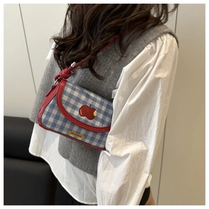 Blue and white checkered crossbody bag with red trim and a cute apple patch on a model