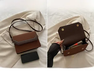 Detail view of the spacious inner compartment of the brown square shoulder bag