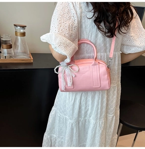 Détail du sac à main rose en cuir avec pendentif en dentelle de perles et bandoulière