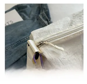 Detail of white pleated fabric shoulder bag with silver metal zipper and purple carabiner