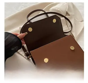 Detail showing the internal structure with golden magnetic snap closure on brown handbag