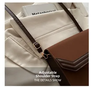 Detailed close-up of the adjustable strap and golden hardware on the brown flap bag
