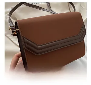 Detail showing high-quality dark brown suede and PU leather stitching on a square bag