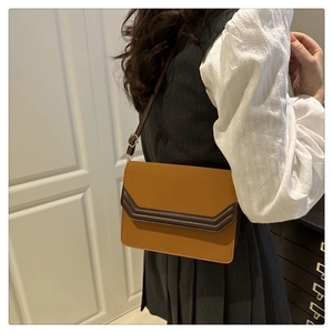 Détail du sac à bandoulière vintage avec rabat contrasté porté par un mannequin