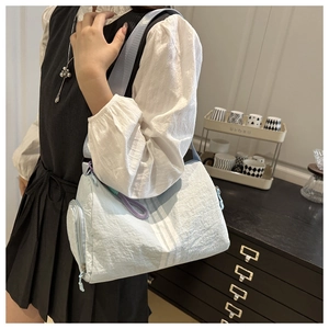 Detail of light blue casual crossbody bag featuring pleated texture and side zipper pocket