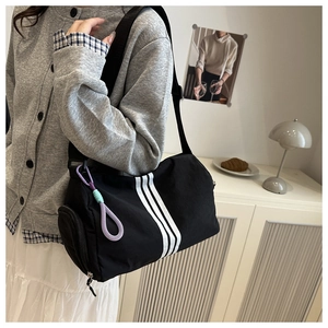 Detailed shot of large black oxford fabric crossbody bag with sporty white stripes