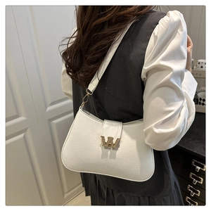 Dettaglio borsa in pelle bianca con logo W dorato scintillante e texture raffinata