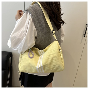 Detail view of yellow crossbody toast bag with white stripes and purple zipper ring puller