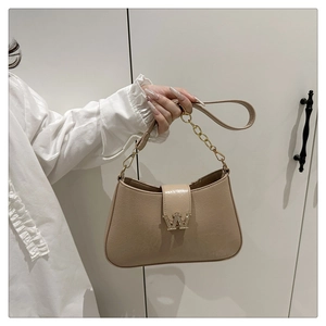 Dettaglio della borsa beige con fibbia a W impreziosita da cristalli e catena dorata