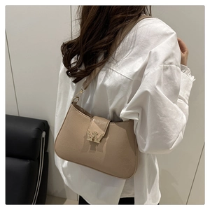 Dettaglio borsa beige con fibbia a W di diamanti e trama in pelle sintetica effetto screpolato