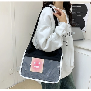 Détail du sac bandoulière en toile avec poche frontale en PVC et carte rose