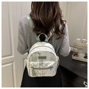 Detailed back view of a mini beige backpack with green bamboo and butterfly prints