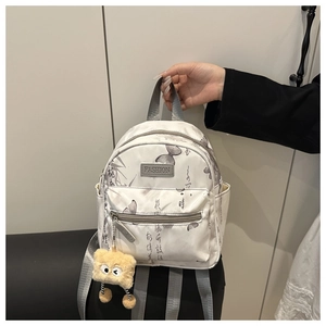 Mini floral white backpack detail with grey butterfly prints and plush yellow charm