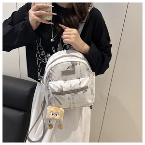Detailed shot of a white nylon mini backpack with gray butterfly and ink-style patterns