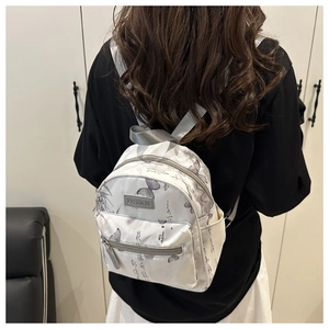 Detail of white nylon mini backpack with butterfly print and silver zipper on model