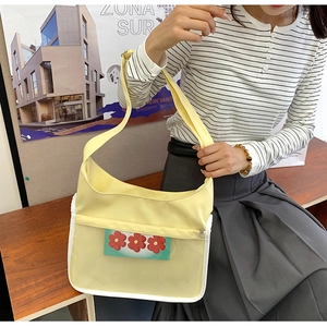 Détail du sac messager jaune clair avec poche PVC transparente et carte à fleurs