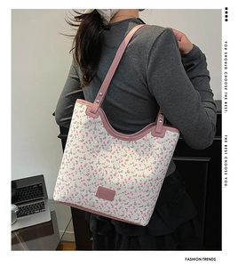 Detailed back view of model wearing a large floral tote bag with pink leather straps