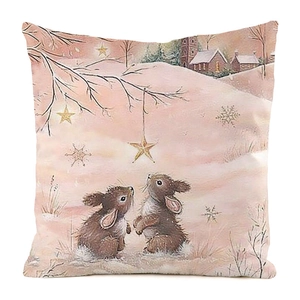 Detail of Christmas pillow cover with rabbits and gold stars in a snowy winter forest