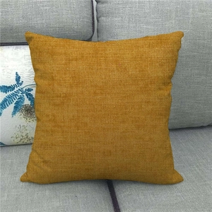 Minimalist solid mustard yellow linen cushion cover on a grey fabric sofa for home decor