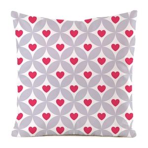 Détail du motif géométrique de cœurs roses sur une taie d'oreiller carrée en fausse soie