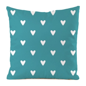 Détail du tissu en soie synthétique douce et du motif coeur blanc sur la housse de coussin bleue