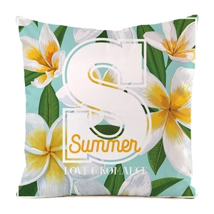 Vue détaillée de la housse de coussin avec fleurs de frangipanier et la lettre S