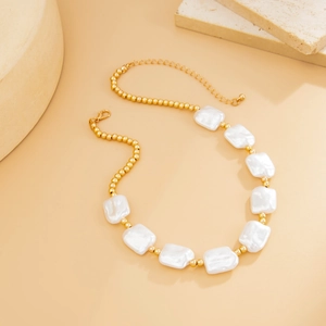 Detailed shot of gold beads and baroque faux pearl necklace with lobster clasp closure
