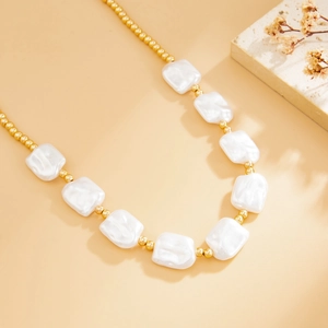 Detailed shot of baroque pearls and gold beads on a luxury layered collar necklace