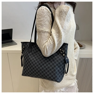Detailed shot of large capacity tote bag with white monogram pattern and gold ring hardware