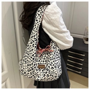 Detail of leopard print tote bag featuring a Fashion label and red checkered lining detail