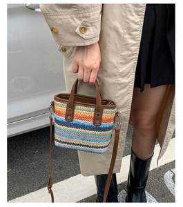 Photo de mode d'un sac seau tissé multicolore avec poignée en cuir et bandoulière fine