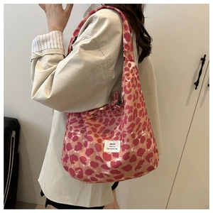 Close-up of pink leopard print tote bag with white woven label on nylon fabric