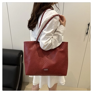 Detail of red woven tote bag showing FASHION logo and high-quality material texture