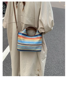 Gros plan d'un sac seau en paille tissée multicolore avec anses rondes marron foncé