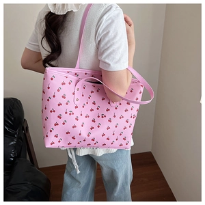Detailed view of pink cherry print tote bag with metal rivet accents on the side