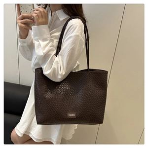 Detailed macro view of dark brown woven texture and Fashion label on the large tote bag