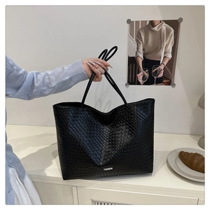 Détail du sac cabas tressé noir avec texture en damier et étiquette Fashion