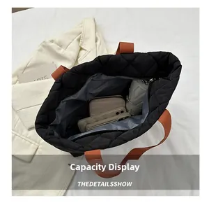 Quilted black tote bag showing spacious interior with phone, wallet, and folding umbrella