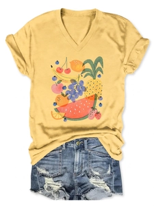Detail of yellow V-neck T-shirt with vibrant fruit print and ripped denim shorts
