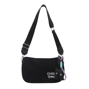 Black nylon crossbody pillow bag with adjustable wide strap and decorative bow pendant