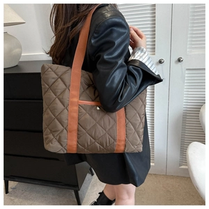 Détail d'un grand sac cabas matelassé avec surpiqûres en losange et large bandoulière