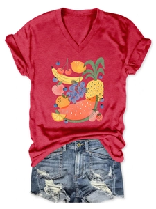 Detail of red V-neck T-shirt with fruit print paired with blue denim shorts on white background